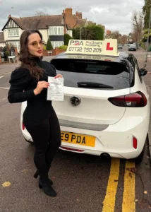 female student who has passed her driving test standing near Pro Drivers Academy learner car on cannaught avenue in chingford near the test centre