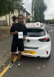 posing in farnley road with his pass certificate after passing his manual driving lesson with Pro Drivers Academy